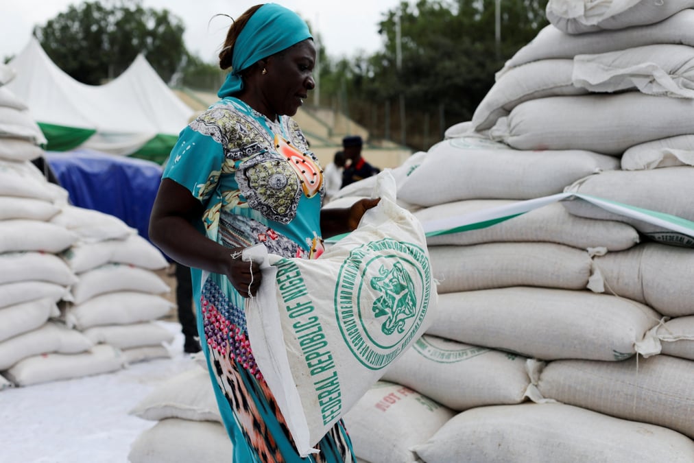 Photo d'une femme qui recoit un sac de nourriture du gouvernement lors de la distribution de produits alimentaires
