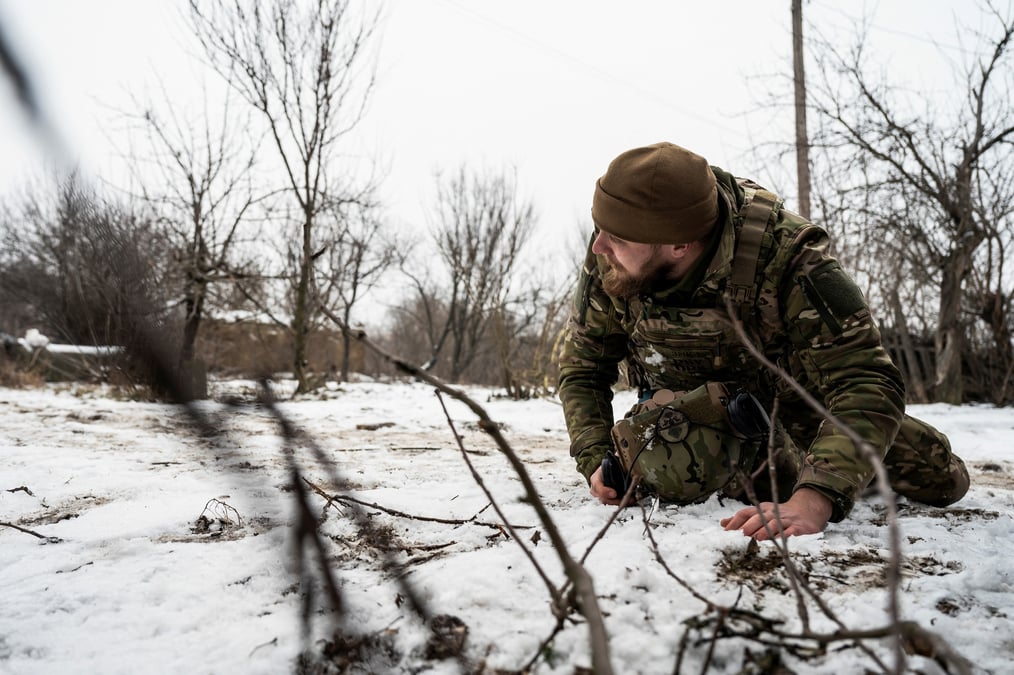 Un soldat ukrainien se couche pendant un bombardement des troupes russes sur la ligne de front dans la region de donetsk