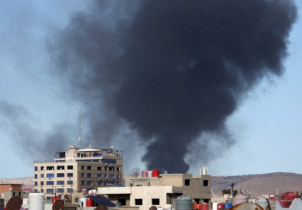 De la fumee s'eleve de la ville de qamishli, sous controle kurde, dans le nord-est de la syrie