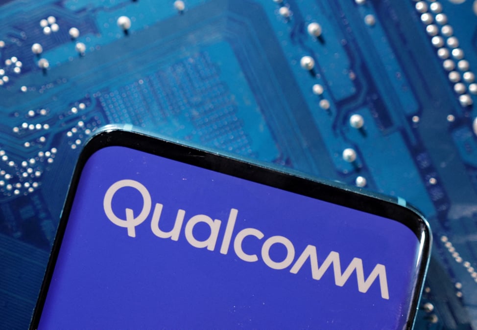 Un smartphone avec un logo qualcomm affiche pose sur une carte mere d'ordinateur