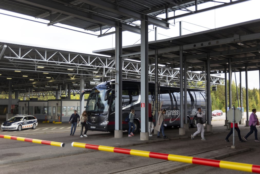 Des passagers sortent d'un bus au poste frontiere de vaalimaa