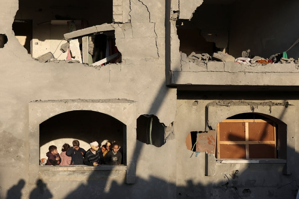 Les Palestiniens inspectent les dégâts sur le site d'une frappe israélienne sur une maison, au milieu du conflit Israël-Hamas, à Deir Al-Balah