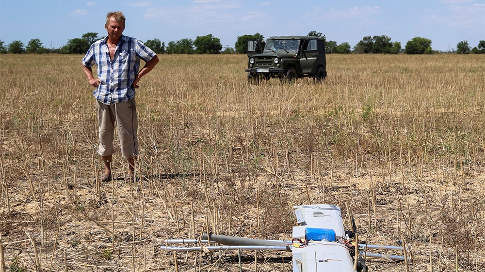 Juillet 2025, dans la région de Kherson : un fermier observe un drone tombé dans son champ.