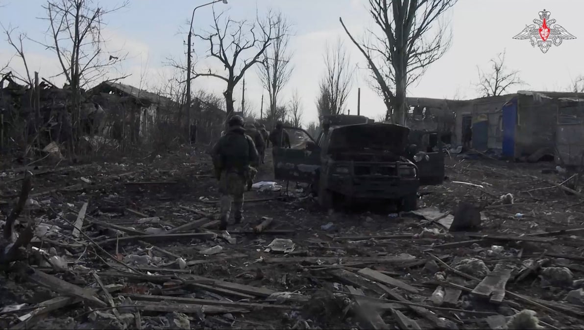 Photo des militaires russes qui marchent au milieu des decombres, a proximite d'une voiture endommagee, a avdiivka