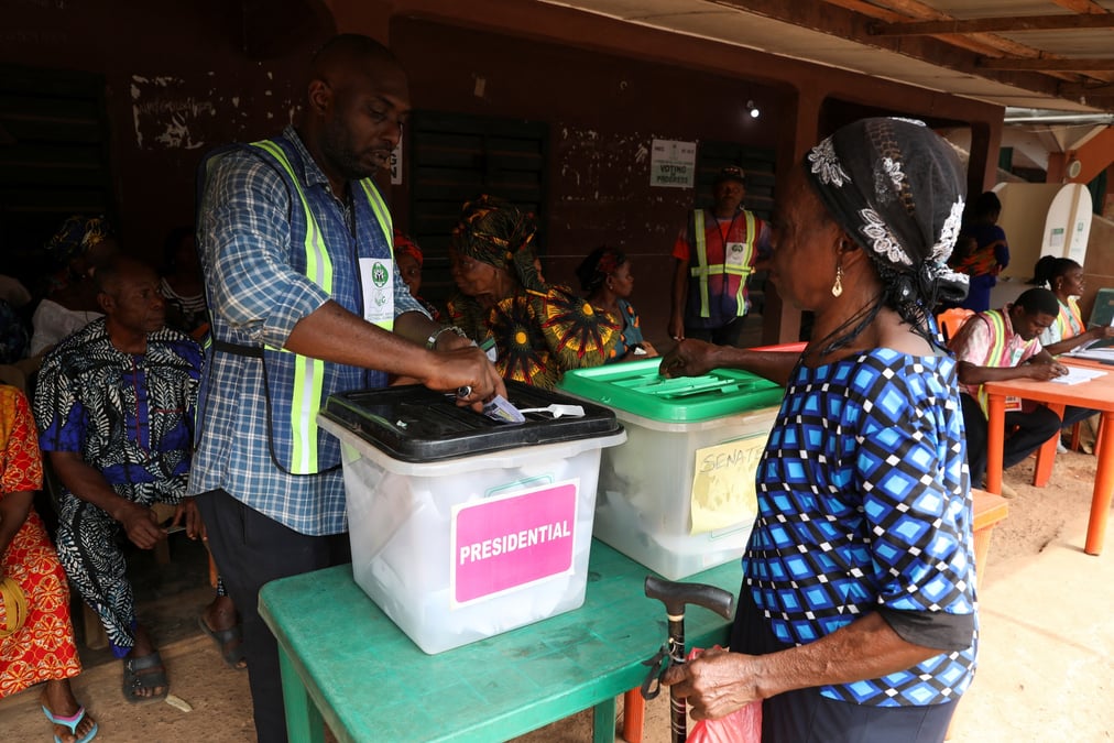 Photo d'un homme qui aide une femme a voter pendant les elections presidentielle et legislatives au nigeria