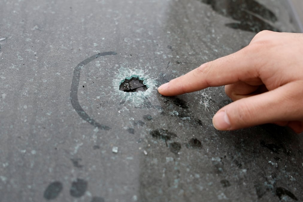 Un palestinien pointe du doigt un impact de balle dans sa voiture a houwara, en cisjordanie occupee par israel