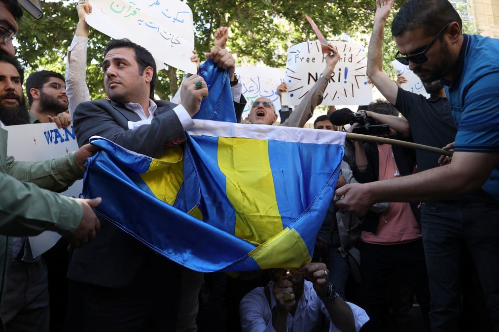 Des manifestants a teheran brulent le drapeau suedois lors d'une manifestation contre un homme qui a brule une copie du coran a stockholm