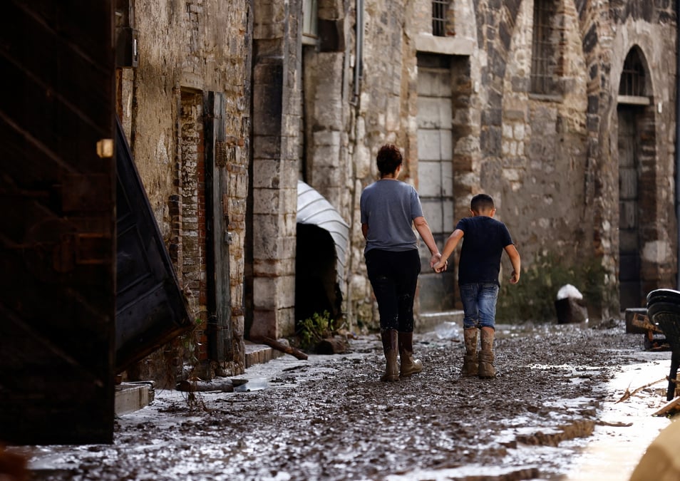 Une femme et un enfant marchent apres les inondations meurtrieres qui ont frappe la region centrale italienne des marches, a cantiano