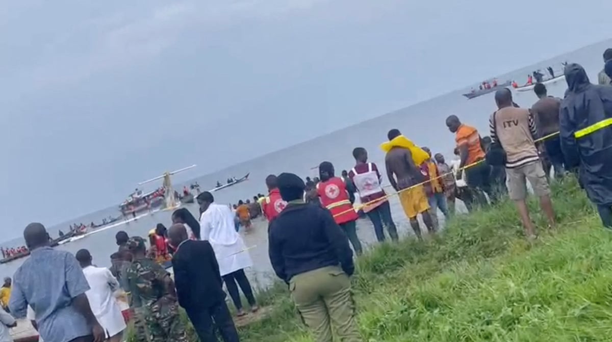 Des personnes regardent l'avion de precision air qui s'est ecrase dans le lac victoria, en tanzanie