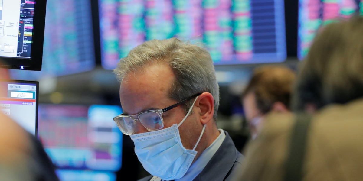 Un trader avec son masque de protection au New York Stock Exchange. Un accord sur un plan de relance de 2.000 milliards de dollars a été annoncé par le chef de la majorité républicaine au Sénat américain afin de relancer l'activité.
