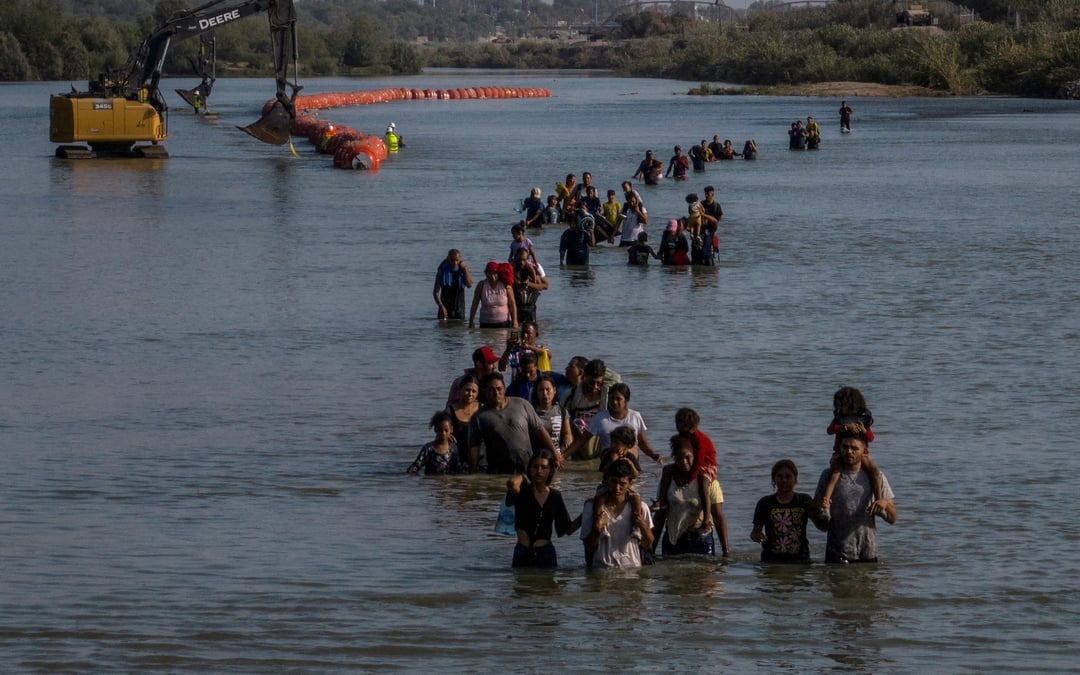 Des personnes migrantes traversant le rio grande entre le mexique et les etats-unis