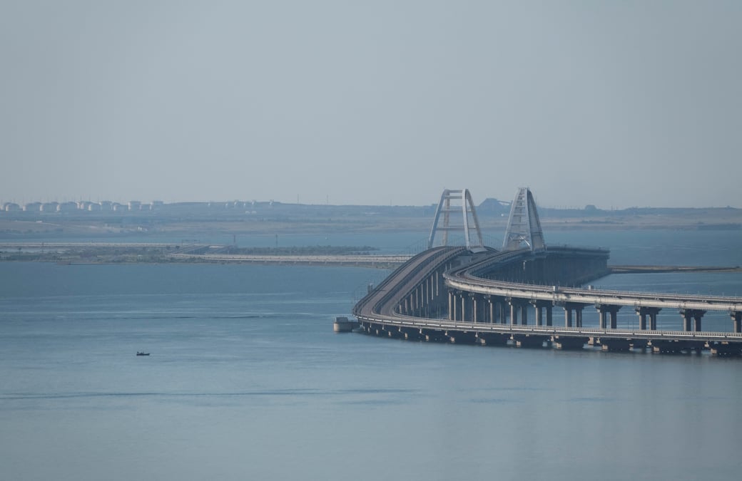 Un bateau navigue a cote du pont de crimee qui relie le continent russe a la peninsule de l'autre cote du detroit de kertch