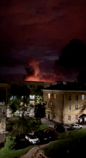 La fumee d'un incendie est eclairee par un flash de lumiere lors d'une attaque de drone a pskov