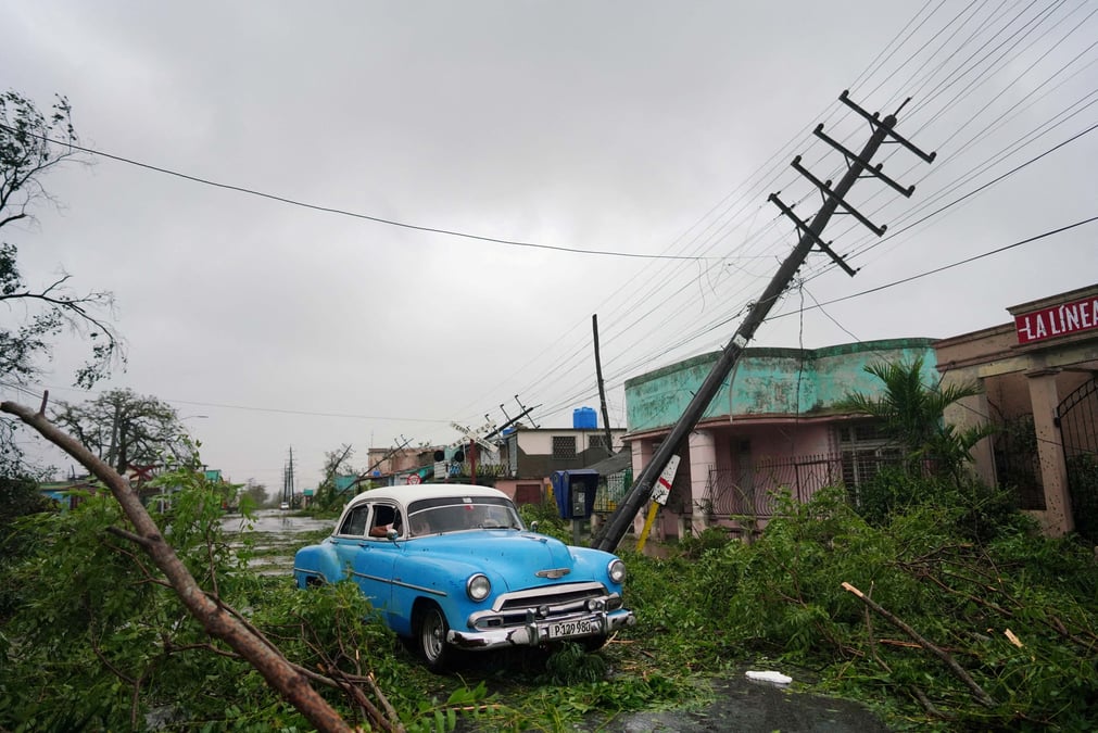 Une voiture de collection passe a cote de debris causes par l'ouragan ian lors de son passage a pinar del rio, a cuba
