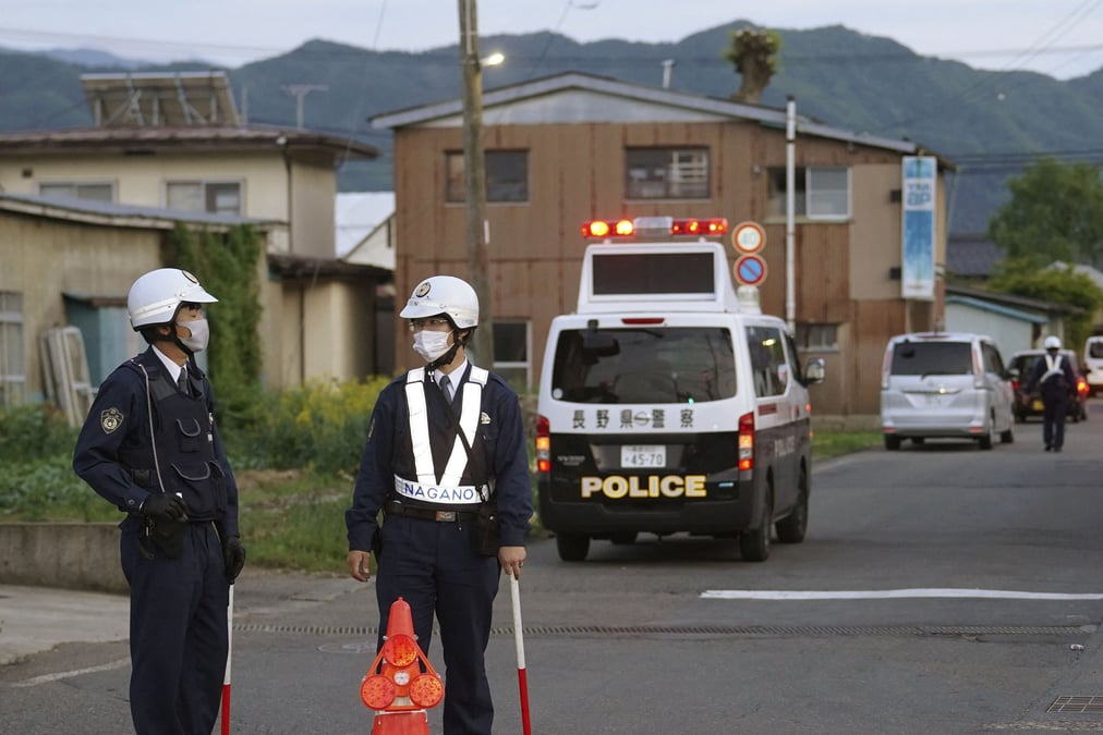 Des policiers se tiennent pres de la scene d'une agression a l'arme blanche et d'une fusillade a nakano