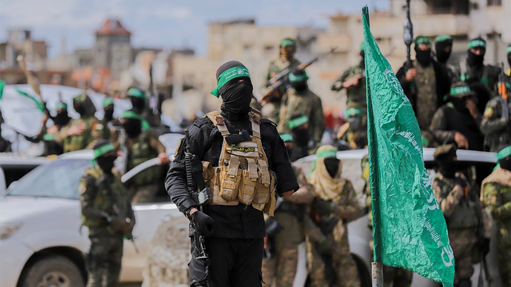Des combattants du Hamas sur le lieu de la remise des otages israéliens au camp de réfugiés de Nuseirat, dans le centre de la bande de Gaza, dans le cadre de la septième libération d'otages, le 22 février 2025.