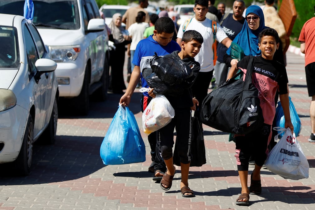 Photo des familles de membres du personnel d'organisations internationales transportent leurs affaires pour se refugier dans un centre des nations unies apres que l'unrwa a annonce avoir transfere son centre d'operations central au sud de la bande de gaza