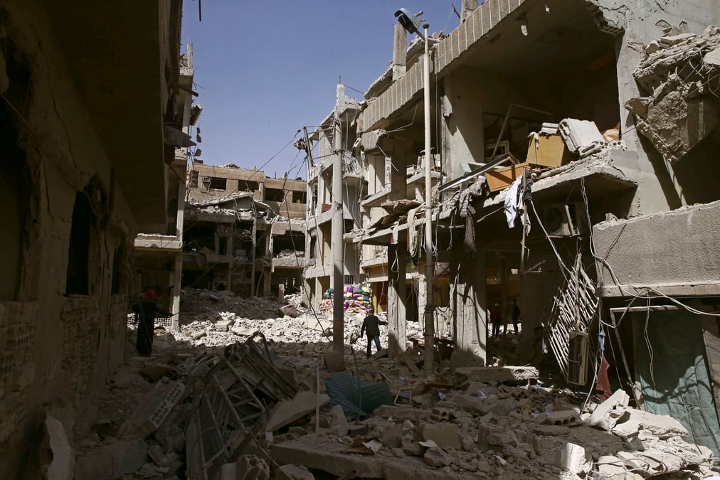 A man walks on rubble of damaged buildings in the besieged town of douma