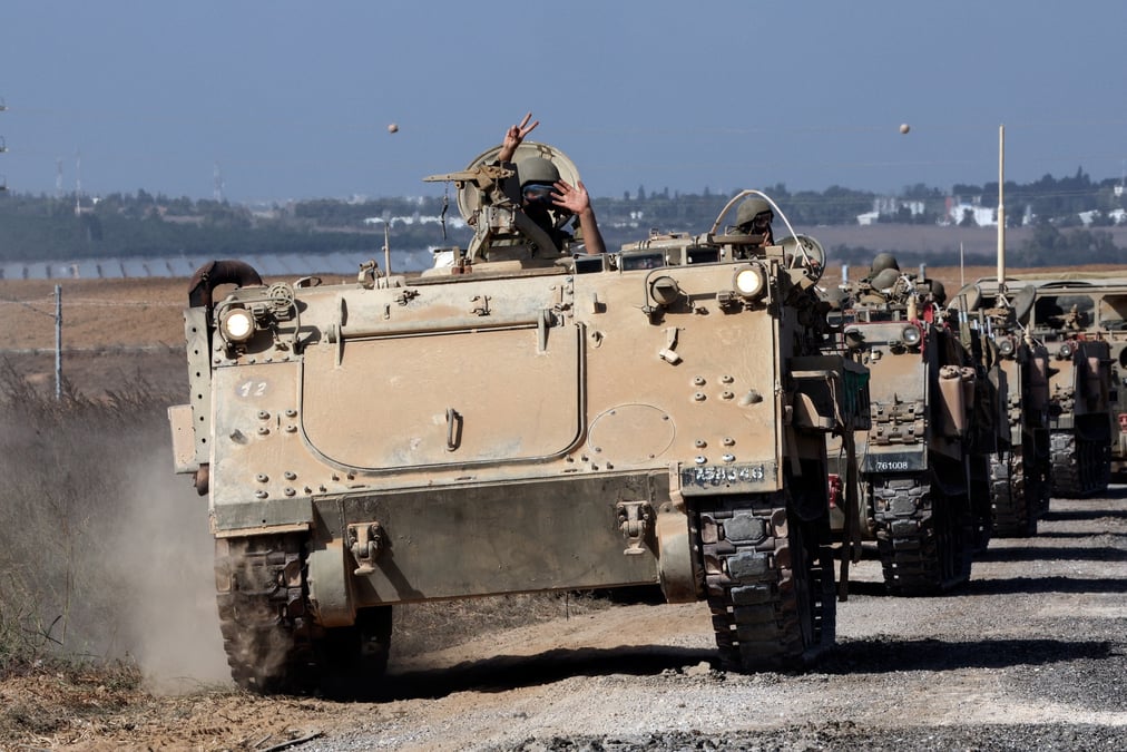 Un convoi de vehicules blindes de transport de troupes prend position pres de la frontiere entre israel et la bande de gaza