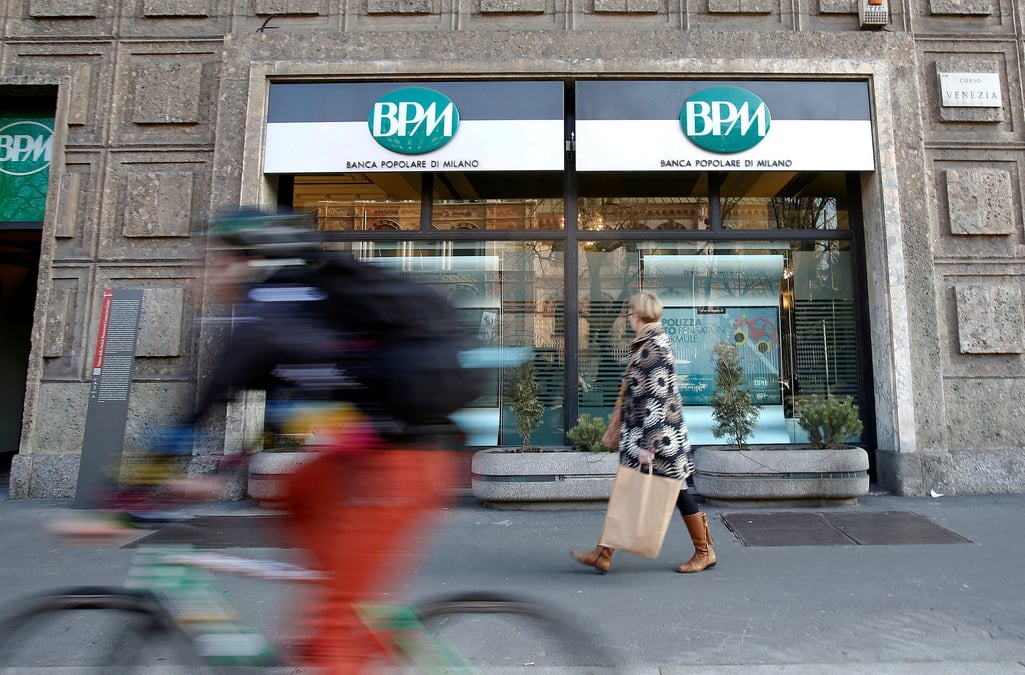 Une femme marche devant la banca popolare di milano (bpm), dans le centre de milan