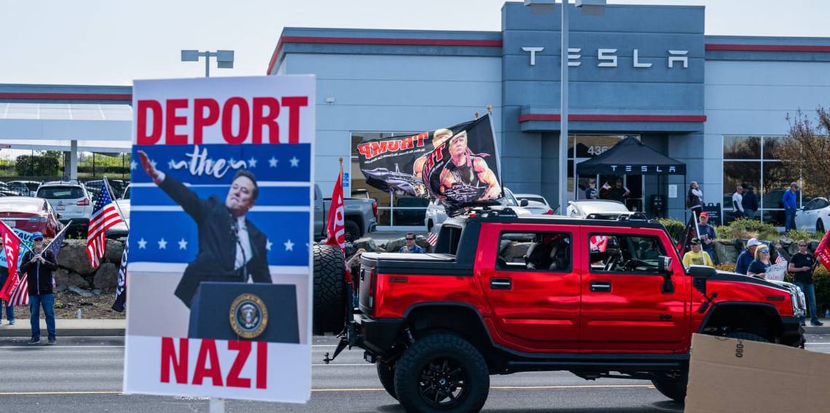 Des manifestants anti-Tesla brandissent des pancartes en face d'un concessionnaire à Rocklin (Californie), devant des partisans de Trump, ce samedi 29 mars.