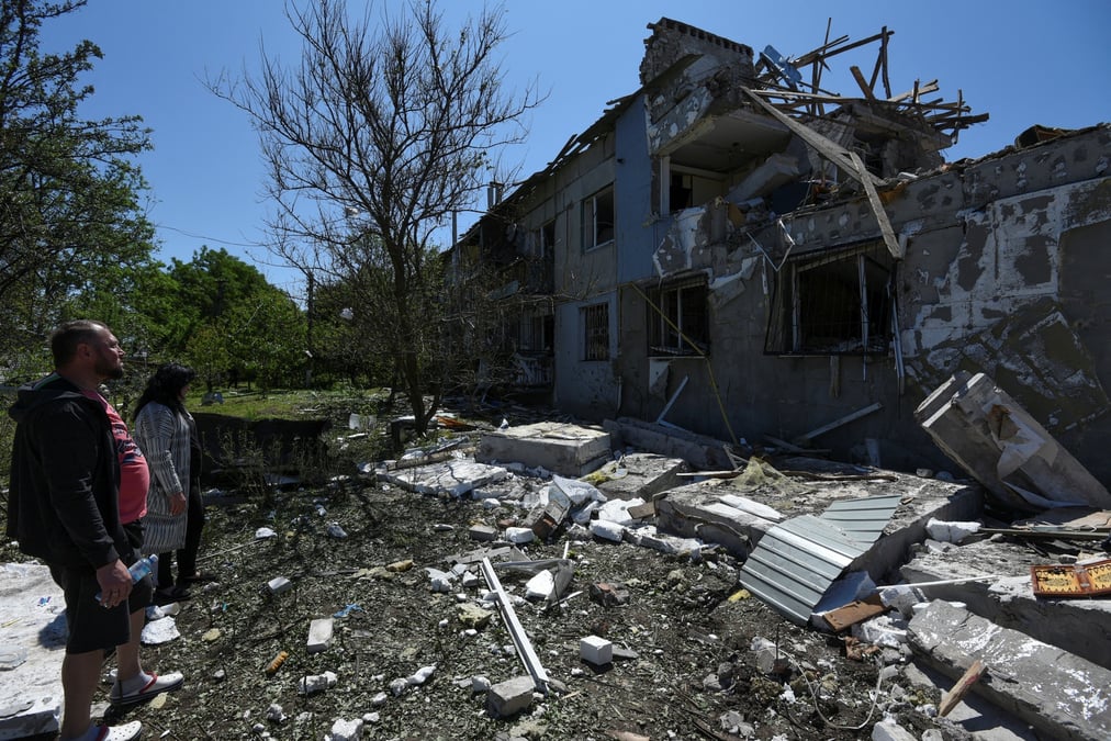 Photo des residents locaux qui se tiennent a cote d'un immeuble fortement endommage par une frappe de missiles russes dans la ville de pidhorodne, au nord de dnipro