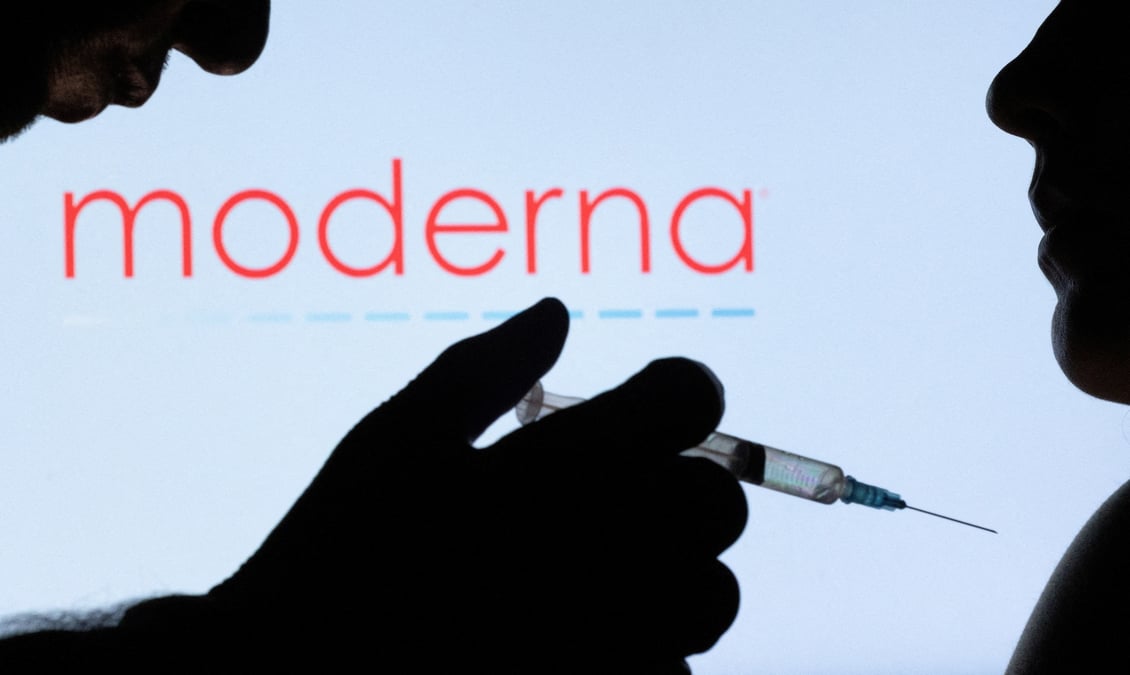 Des personnes posent devant le logo moderna