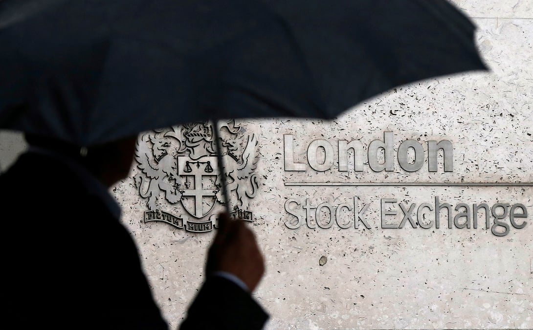 Un homme s'abrite sous un parapluie alors qu'il passe devant la bourse de londres