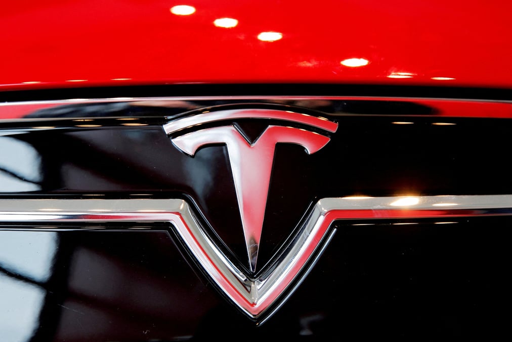 Un logo tesla sur une model s a l'interieur d'une concession tesla a new york