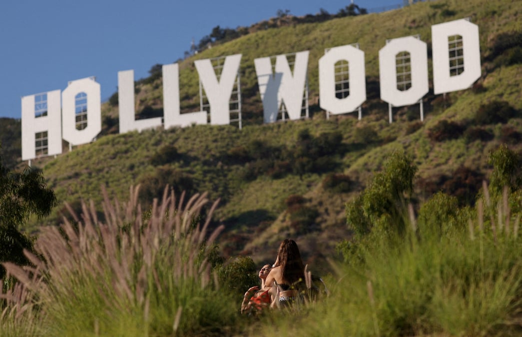 Une femme pose devant le panneau d'hollywood, a los angeles
