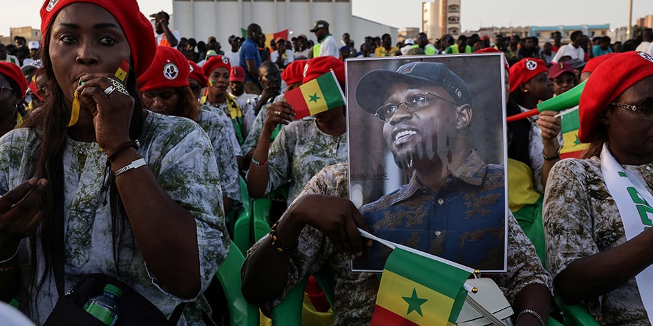 Un partisan tient une affiche de campagne du Premier ministre sénégalais et chef du parti Pastef au pouvoir, Ousmane Sonko, lors de son meeting électoral pour les prochaines élections législatives anticipées.