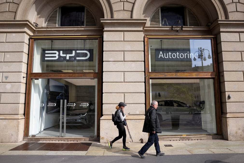 Des personnes marchent devant un magasin byd auto a milan