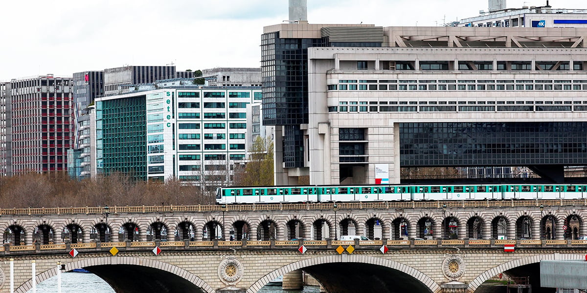 Une vue du ministère de l'Économie et des Finances de Bercy alors qu'un métro exploité par le réseau de transport parisien RATP passe sur le pont de Bercy à Paris, France, le 29 mars 2024.