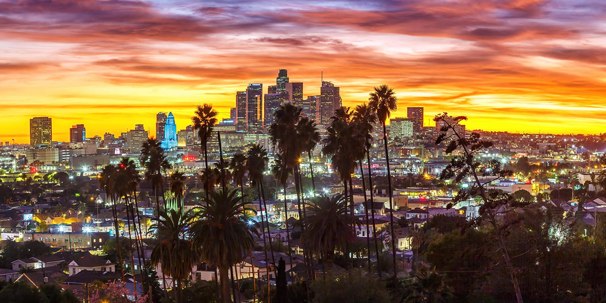 Vue sur le centre-ville de Los Angeles avec des palmiers au coucher du soleil dans Panorama California à Los Angeles, États-Unis.