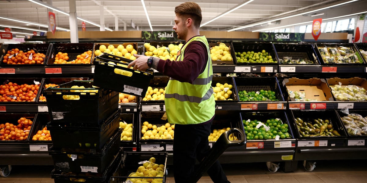 Un employe range des produits dans un supermarche sainsbury's a richmond, dans l'ouest de londres
