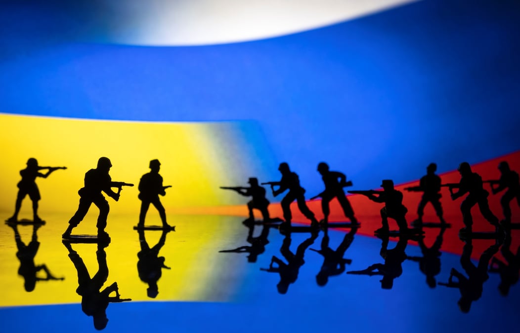 L'illustration montre des figurines de l'armee sur fond de couleurs des drapeaux ukrainien et russe