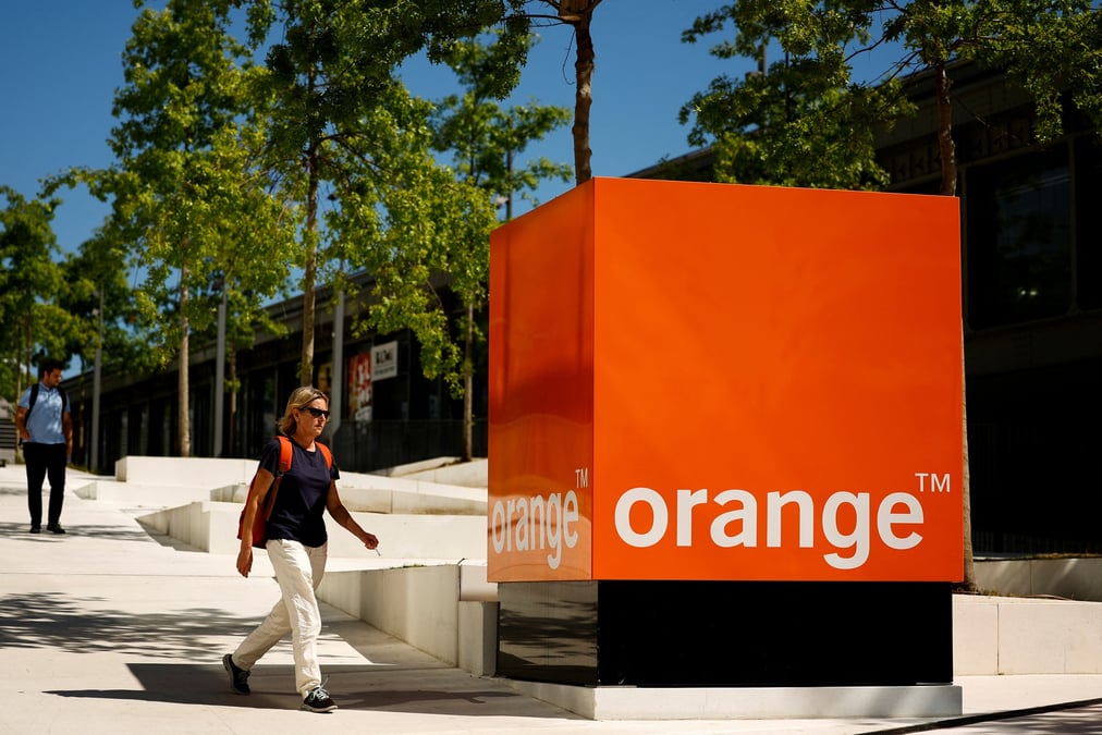 Une femme passe devant le logo d'orange au siege de la societe a issy-les-moulineaux