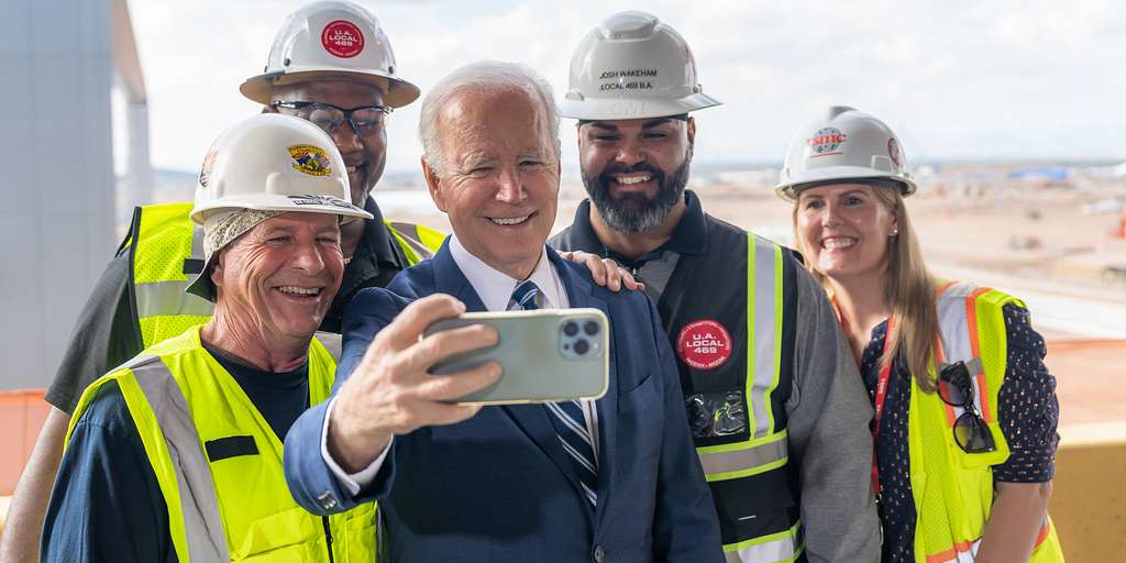 Le président américain Joe Biden posant avec des ouvriers sur le chantier d'une usine TSMC à Phoenix, en Arizona.