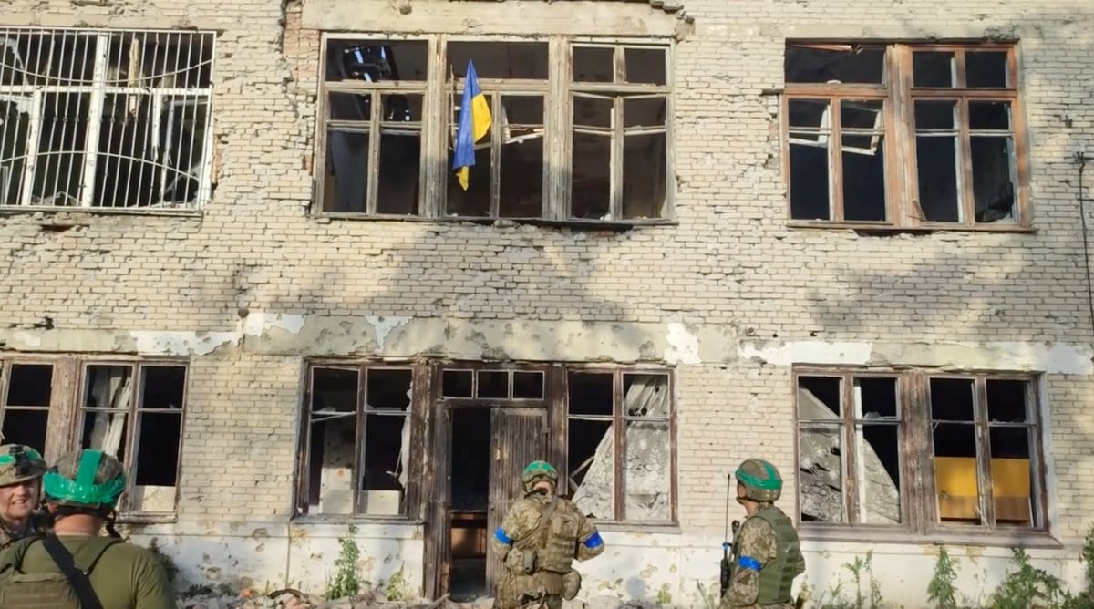 Des soldats ukrainiens devant un batiment portant le drapeau ukrainien, lors d'une contre-offensive, a blahodatne, dans la region de donetsk, en ukraine.