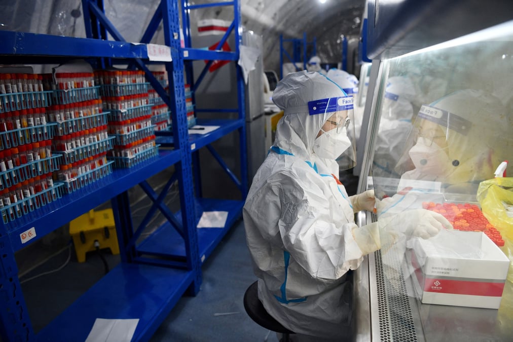 Le personnel teste des echantillons a l'interieur d'un laboratoire installe dans un centre sportif a chengdu, en chine
