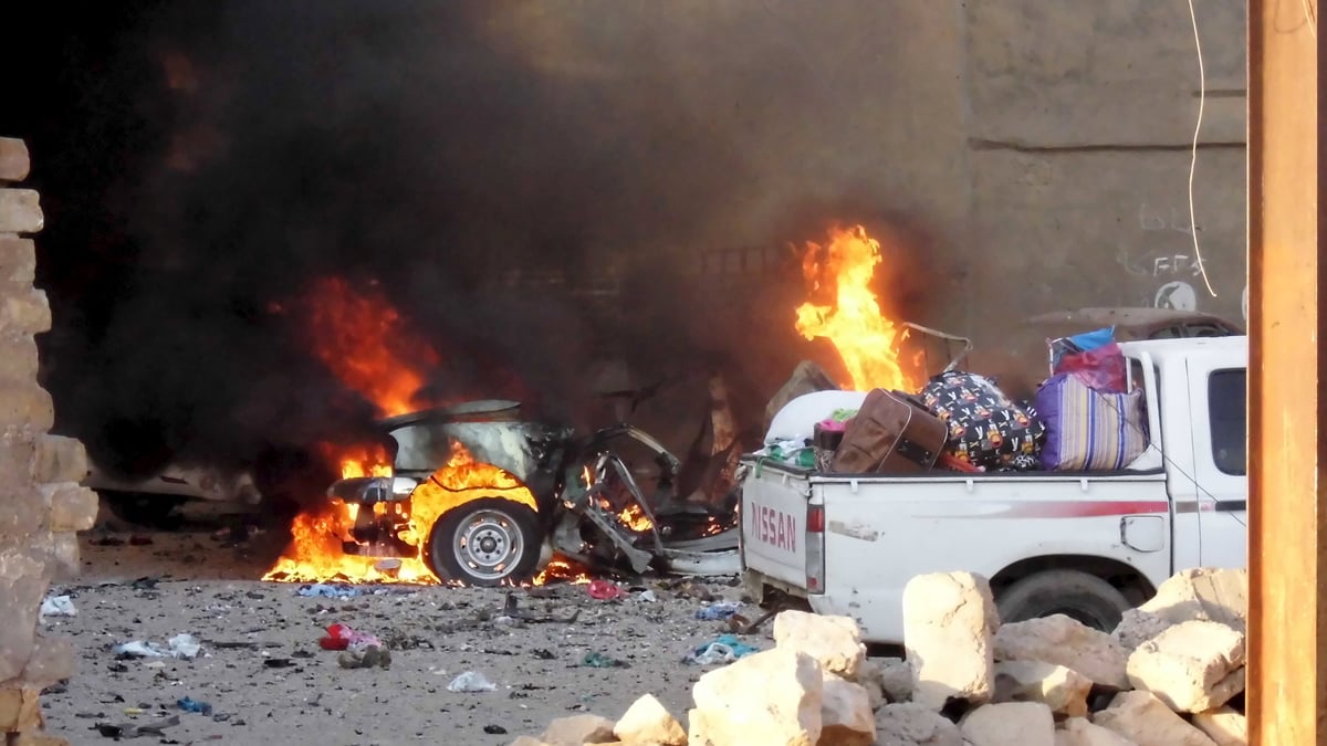 A car is engulfed by flames during clashes in the city of ramadi