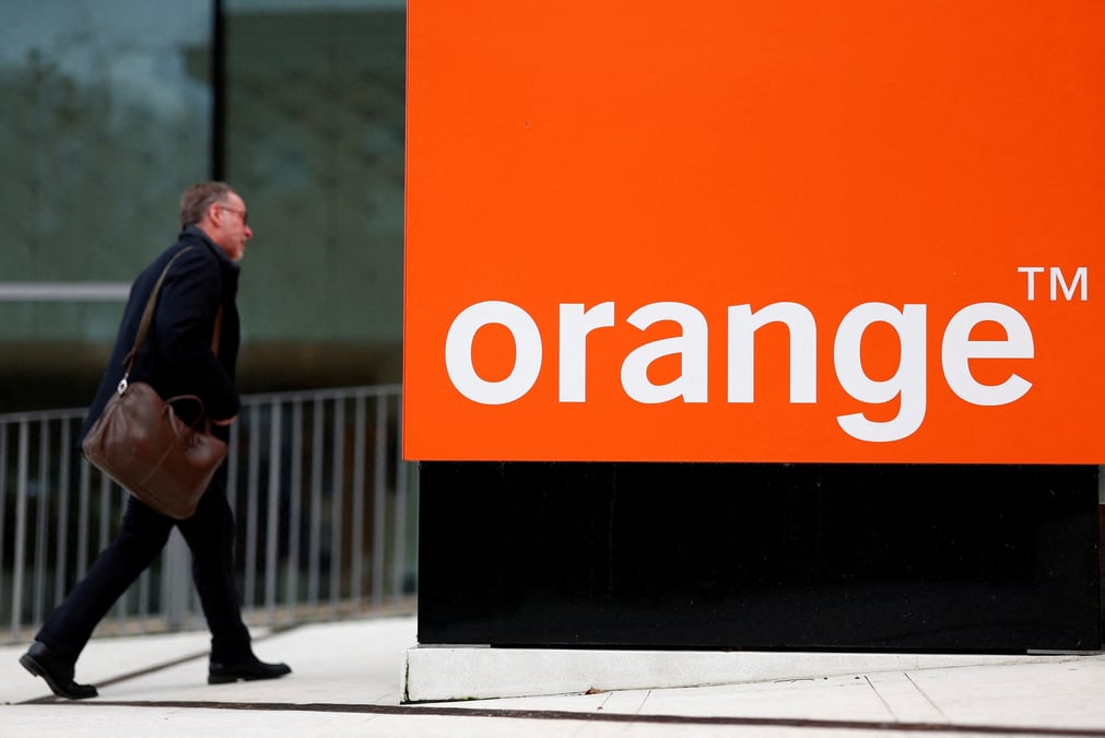 Un homme passe devant le logo de french orange pres de paris