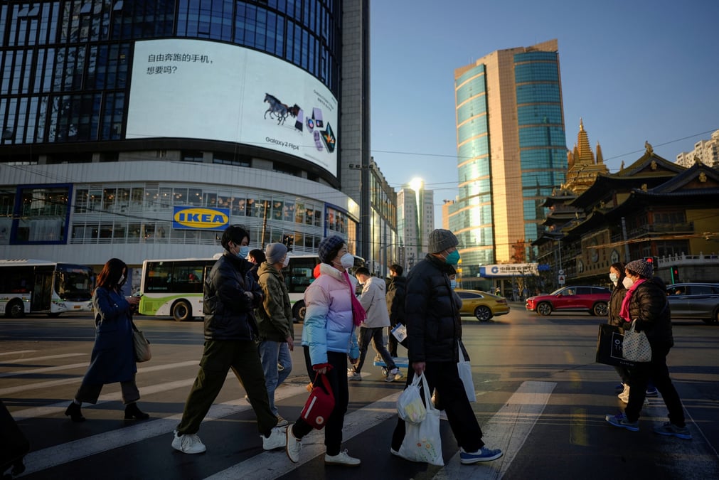 Des personnes portant des masques de protection traversent une rue a shanghai