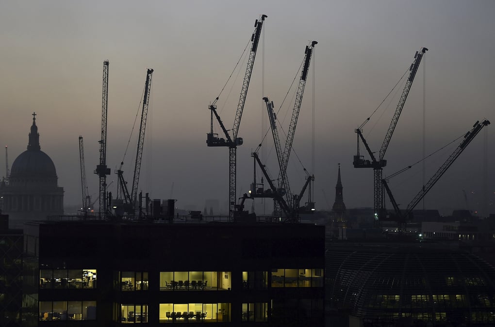 Des bureaux au crepuscule devant la cathedrale saint-paul et des grues de construction a londres