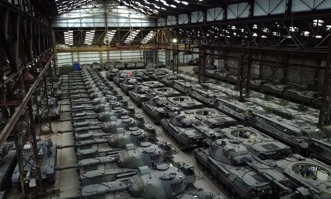 Des dizaines de chars leopard 1 de fabrication allemande et d'autres vehicules blindes sont vus dans un hangar a tournais
