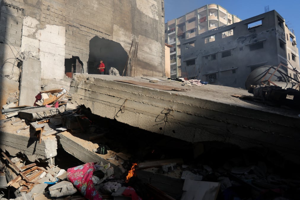 Photo des palestiniens qui inspectent une maison detruite lors d'une frappe israelienne, a khan younis