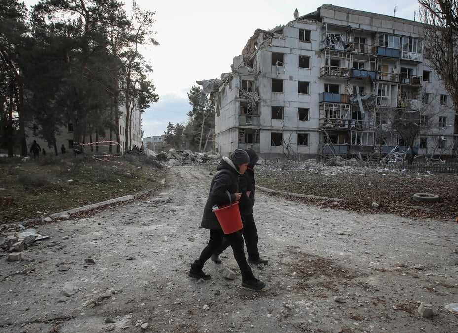 Des habitants marchent pres d'un batiment residentiel endommage par un tir de missile russe, pres de la ville de chuhuiv, dans la region de kharkiv
