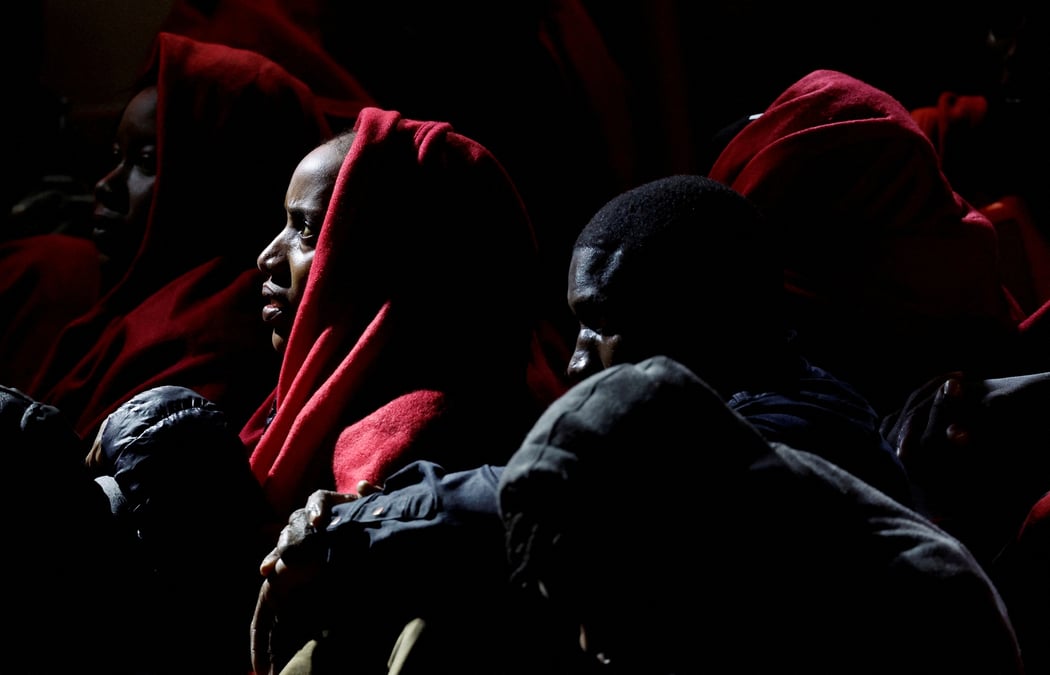 Des migrants attendent avant de debarquer d'un navire des gardes-cotes espagnols dans le port d'arguineguin sur l'ile de grande canarie