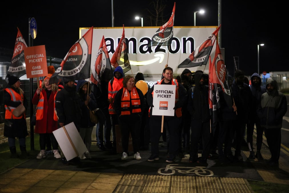 Des personnes brandissent des pancartes lors d'une mobilisation devant l'entrepot d'amazon dans la ville anglaise de coventry a l'occasion du black friday