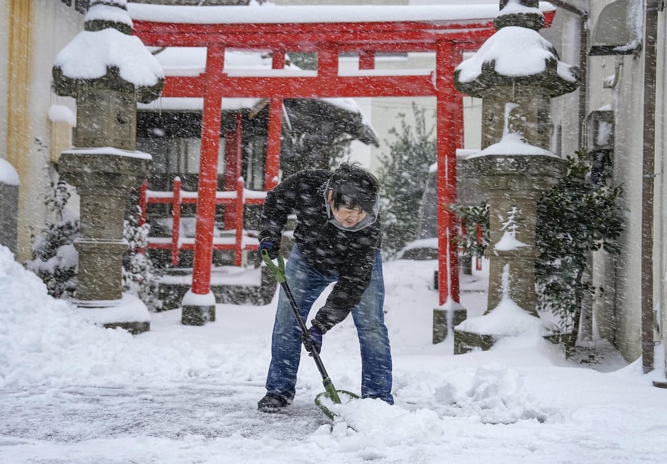 Un homme deblaie la neige devant un sanctuaire a tottori